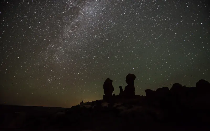 the Milky Way arcs above silhouetted stone pinnacles