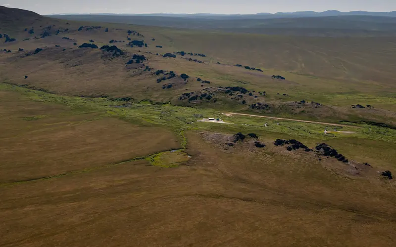 A vast expanse of undulating hills with granite spire jutting from the top.