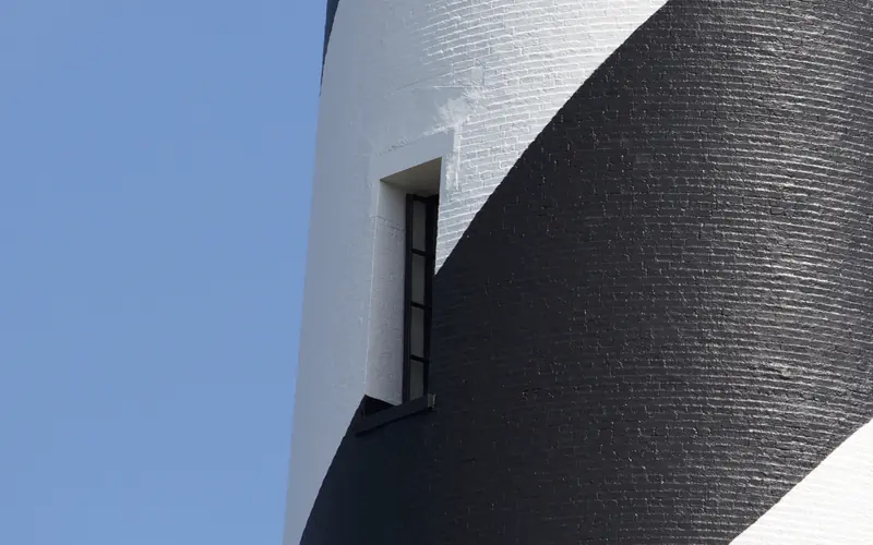 Black and white painting of the brick Cape Hatteras Lighthouse.