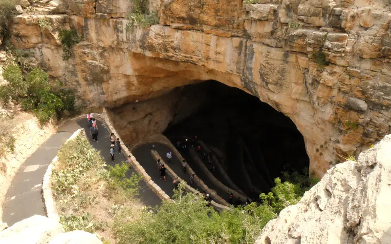 Photo of the Natural Entrance to Carlsbad Cavern with visitors hiking down the trail.