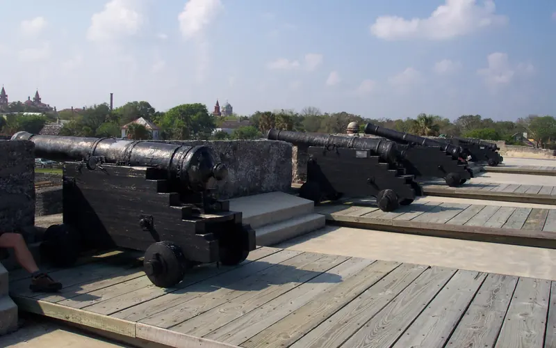 Four black iron cannon mounted on carriages line the walls of the Castillo.