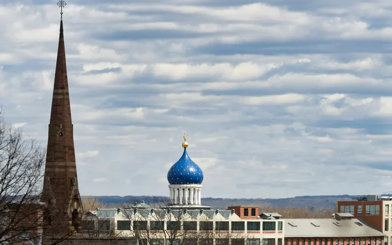 The Blue Onion Dome of the Armory and the spire of the Church against a cloudy blue sky.