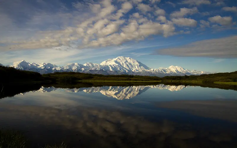 snowy mountains reflected in a pond