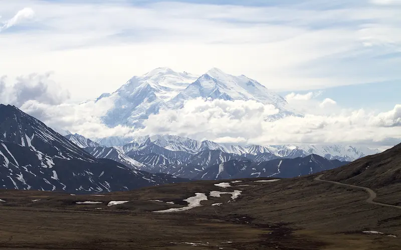 a vast white mountain looming over a brown landscape