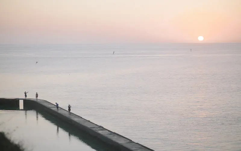 Park visitors enjoy a sunset on the moat wall.