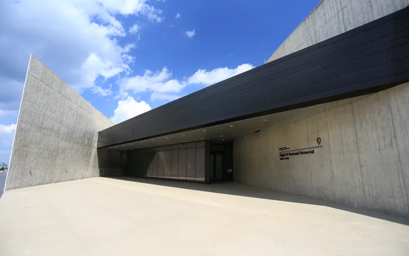 Tall gray walls with a black metal overhang and glass walls