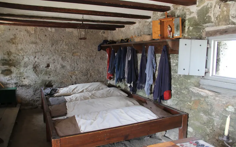 Wooden bunks and uniform items in the soldier's quarters.