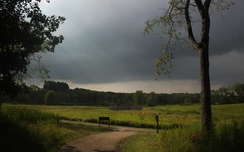 Fort Necessity and the Great Meadow with trail and tree in the foreground
