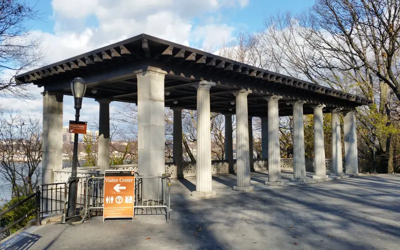 A neoclassic pavilion sits on the hillside, surrounded by trees with the Hudson River below.