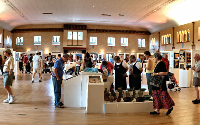 people walking around large room during art show