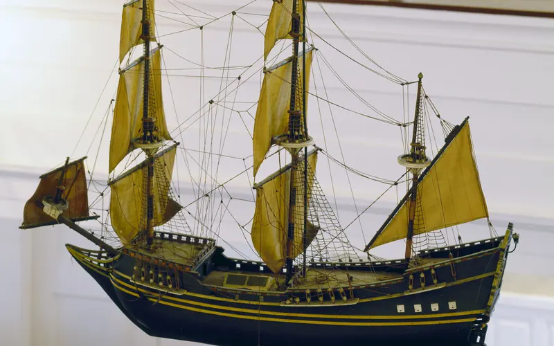 A color photo of a model tall ship hanging inside Gloria Die Church.
