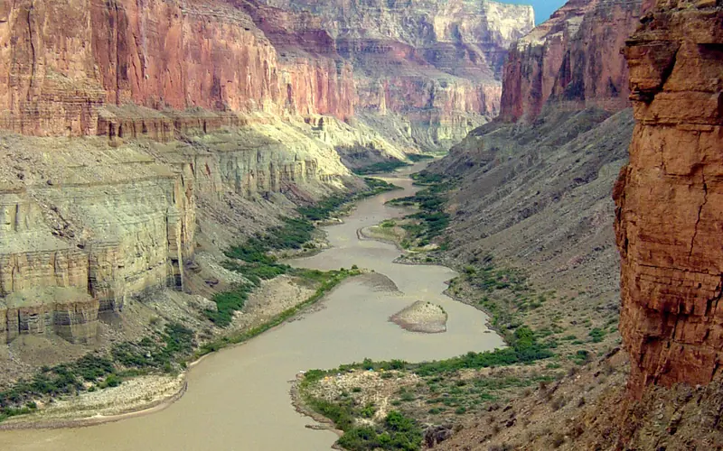 Tall canyon walls frame the wide Colorado river weaving back and forth.