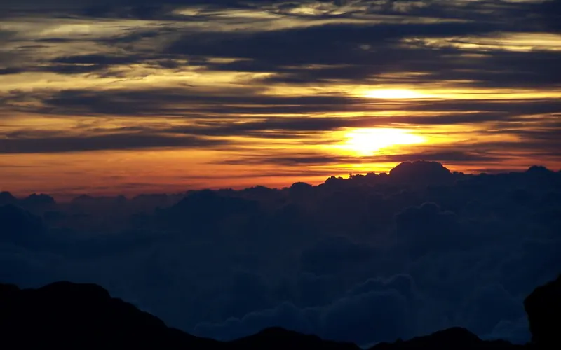 Sun setting over the volcano crater and horizon