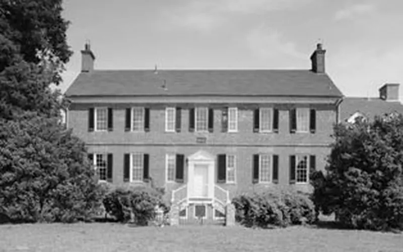 black and white photo of a large two story brick manor