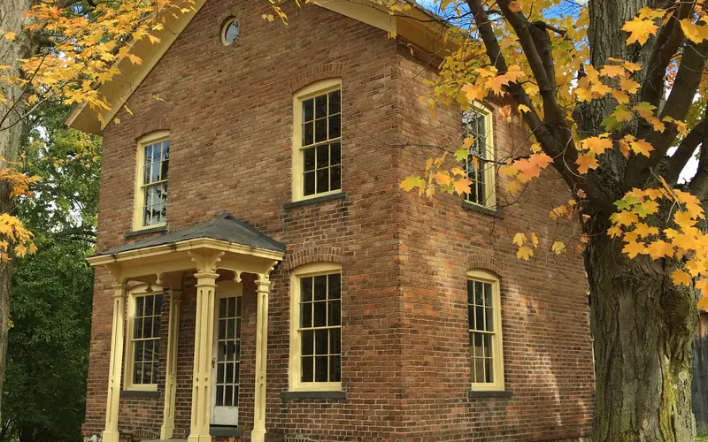 Brick building surrounded by autumn trees