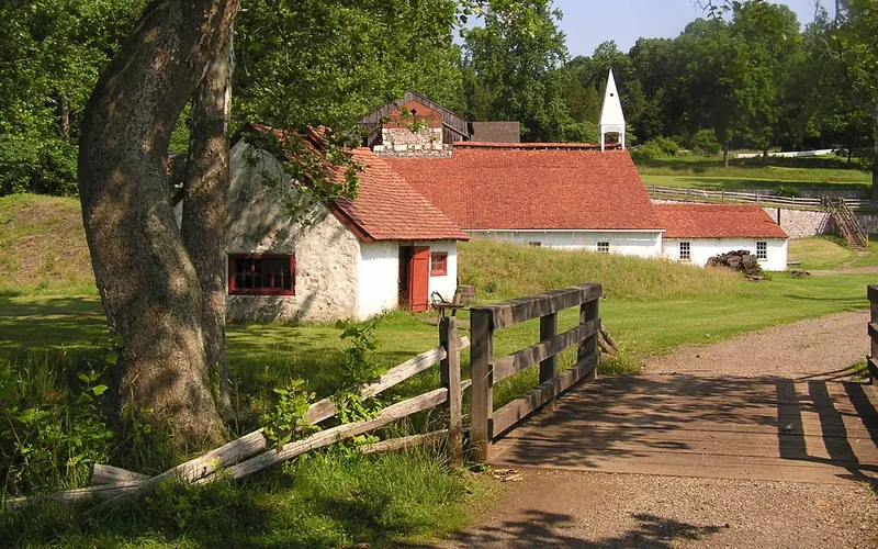 Side view of blacksmith shop with cast house behind it.