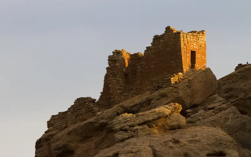 a stone structure resting on a cliff edge