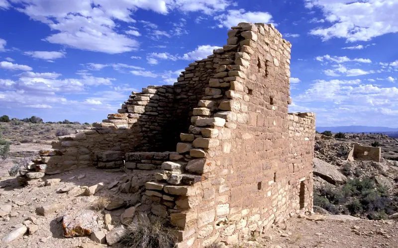 a stone structure with blue sky and clouds overhead