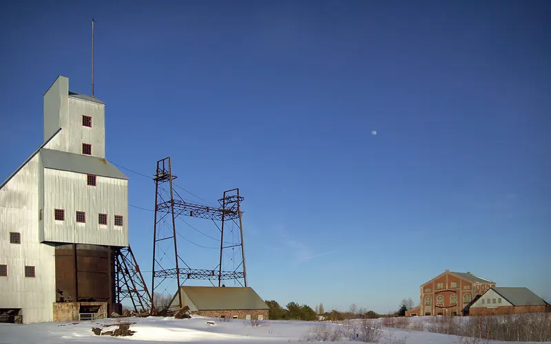140 foot tall industrial building with a steeply pitched roofline under blue skies and snowy ground