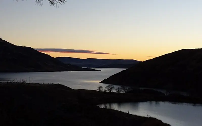 A glow is coming over the horizon and bringing first light to Lake Roosevelt and Crescent Bay Lake.