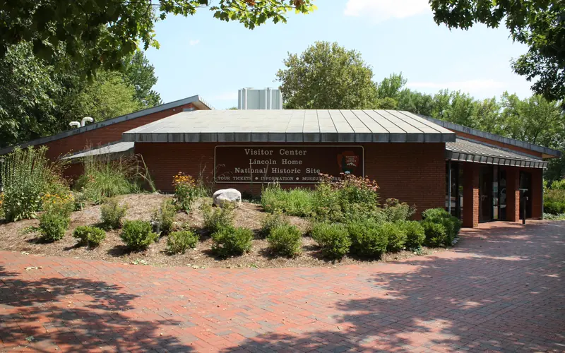 One story brick building with plants and shrubs.