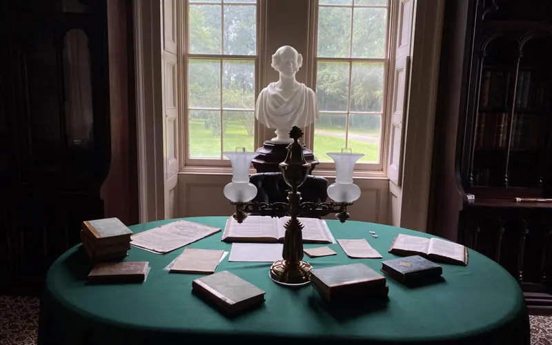 A white marble bust of Martin Van Buren is centered between two windows and behind an oblong desk.