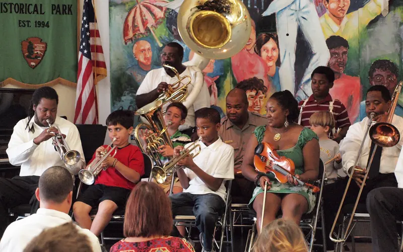 Kids and adults playing instruments on a stage