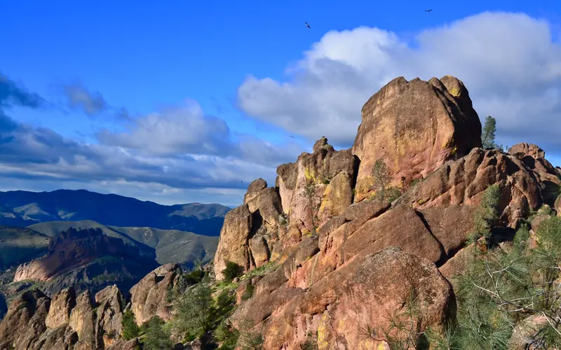 A massive rock spire with California condors flying above the peak.