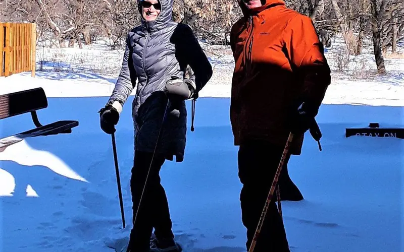 A couple outside in snowshoes smiling at the camera