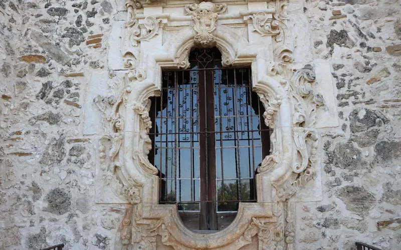 Rose window at mission San Jose, with linestone carvings surrounding a small glass window.