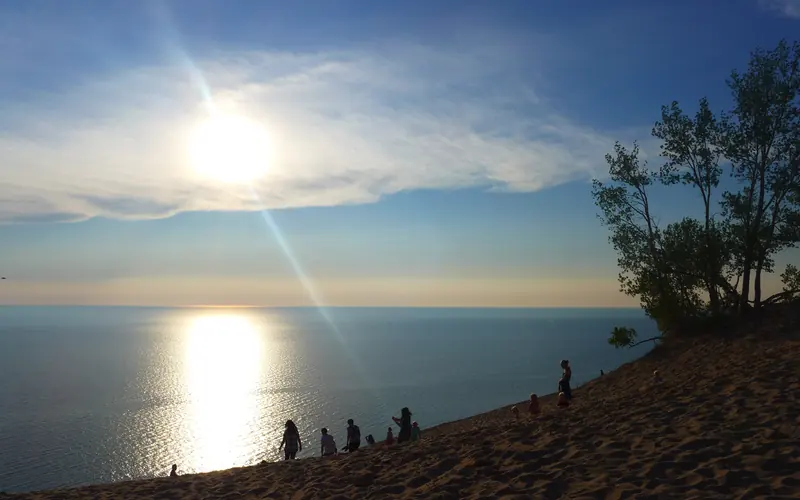A bright sun begins to set into Lake Michigan