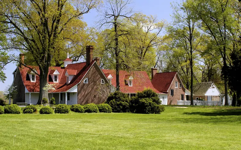Image of a large historic house with green lawn in foreground.