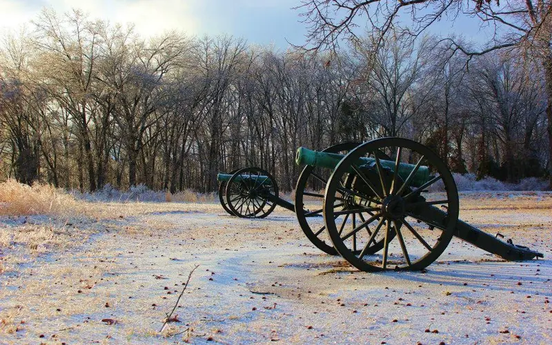 Two cannons sit in an icy field.
