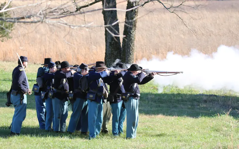Union soldiers fire muskets.