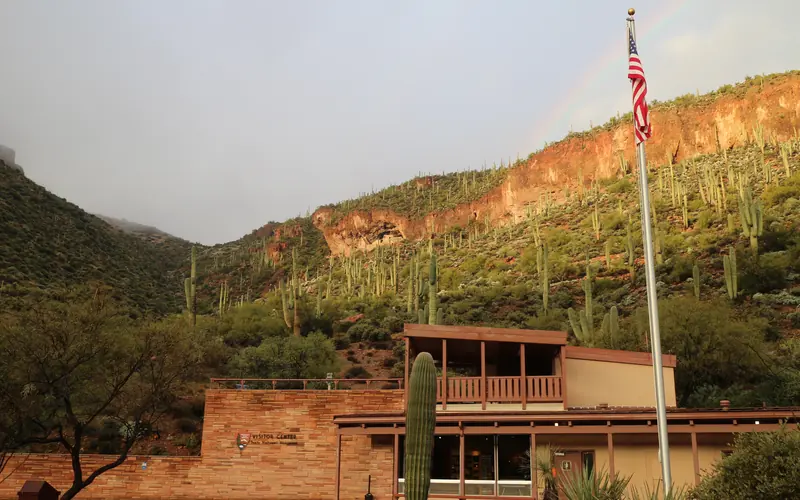 Visitor Center with cliff dwelling and a rainbow in the background.