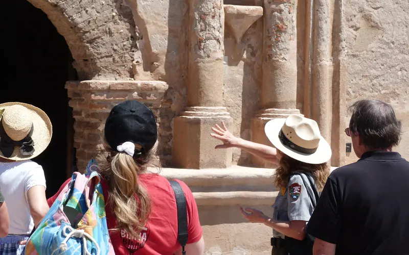 ranger and visitors looking at church facade