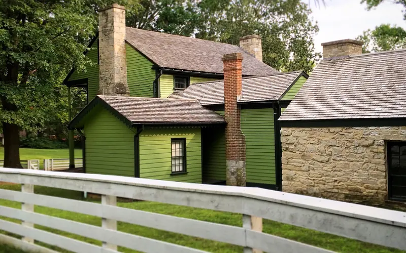 view of house from side and back. The house has several additions. Stone summer kitchen on right