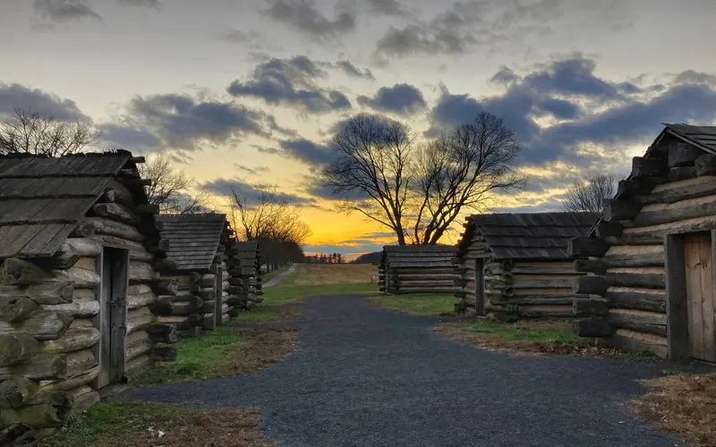 outdoors, log huts, gravel path, sunset, clouds