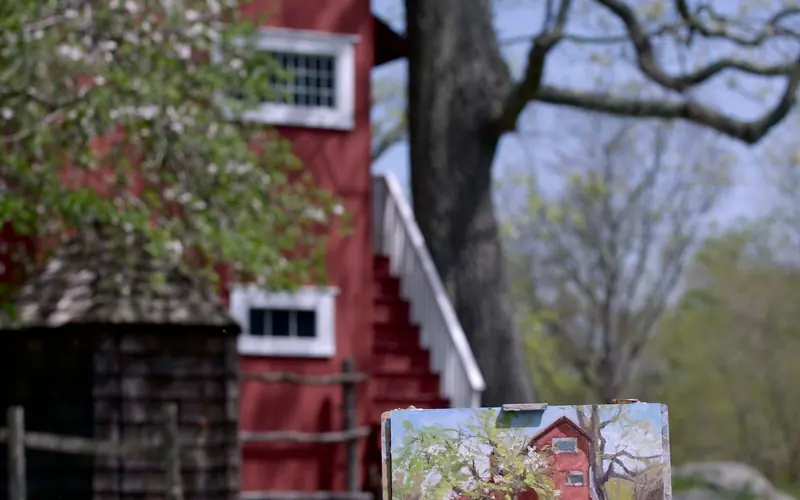 A painting of a red building with the same building in the background.
