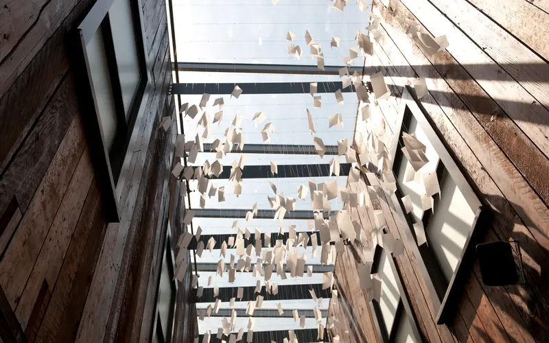 a mobile of letters written on white paper hangs in the museum lobby